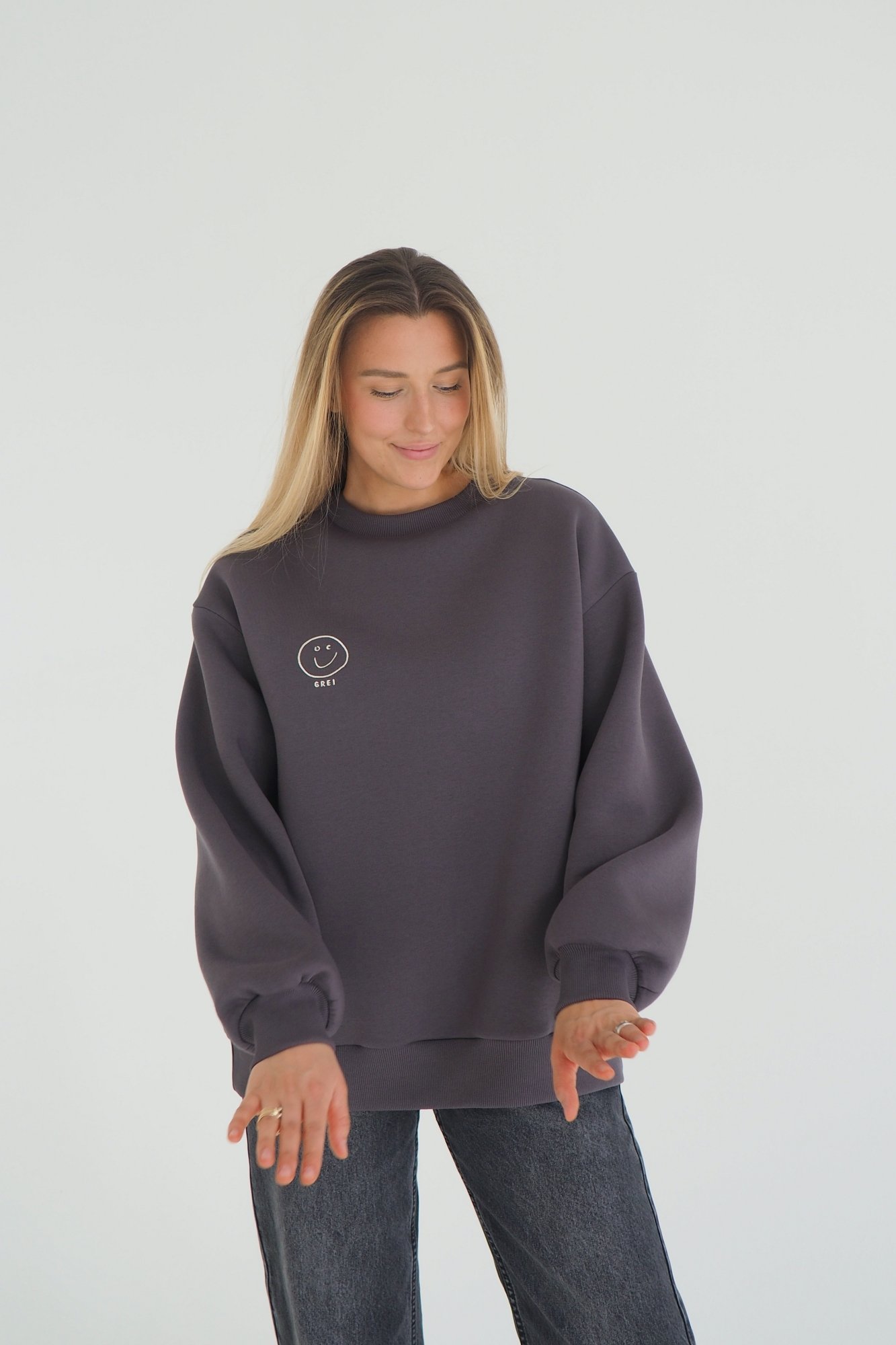 CLOUD sweatshirt is inspired by the cozy puffiness that wraps you in comfort. This oversized sweatshirt is embroidered with the signature GREI studio charm – SMILE. With a lowered shoulder seam and puffed sleeve ends. Oversized fit for ultimate comfort Puffed sleeve ends for a cozy, voluminous appearance Ribbed crew neck, cuffs, and bottom hem for a classic finish Embroidered with the GREI studio SMILE charm Made from long-lasting fabric: 65% cotton, 35% polyester