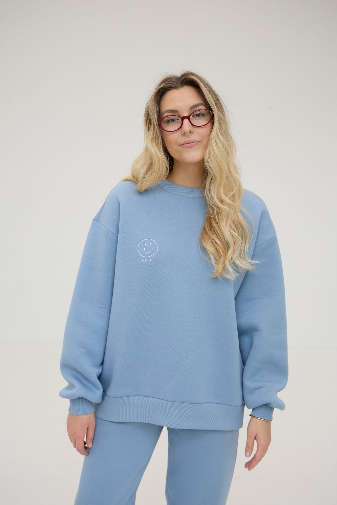 CLOUD sweatshirt is inspired by the cozy puffiness that wraps you in comfort. This oversized sweatshirt is embroidered with the signature GREI studio charm – SMILE. With a lowered shoulder seam and puffed sleeve ends. Oversized fit for ultimate comfort Puffed sleeve ends for a cozy, voluminous appearance Ribbed crew neck, cuffs, and bottom hem for a classic finish Embroidered with the GREI studio SMILE charm Made from long-lasting fabric: 65% cotton, 35% polyester